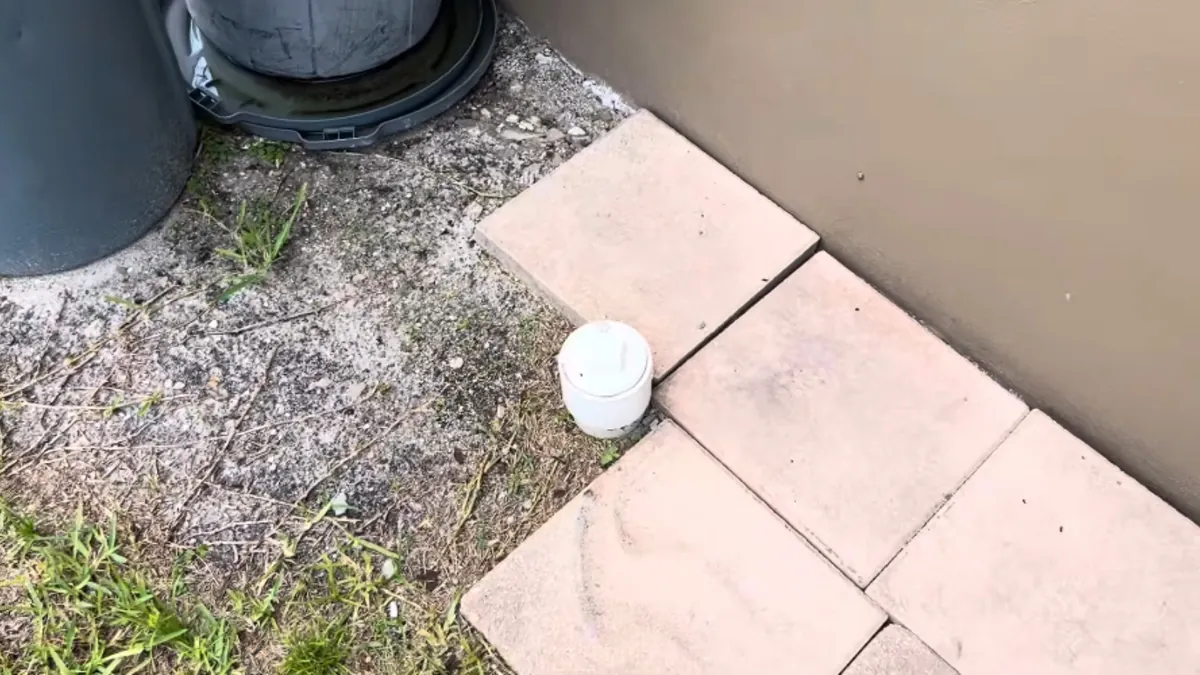 Sewer cleanout cap beside a stucco wall, the access point for drain cleaning in Mission Viejo, CA