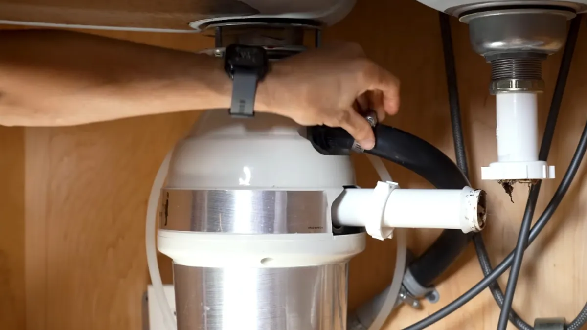 Garbage disposal under a sink showing the reset button and hex socket for repair in Mission Viejo