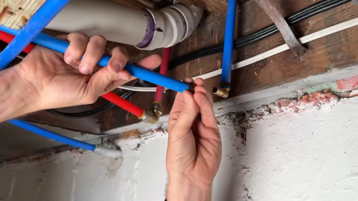 Red and blue PEX tubing in an open wall during a whole-home repipe in Mission Viejo