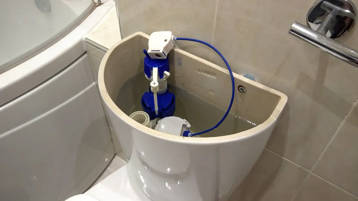 Inside a toilet tank showing the flapper, chain and fill valve for toilet repair in Mission Viejo