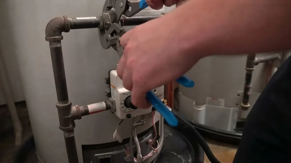Close-up of a water heater gas control valve and temperature dial before a repair in Mission Viejo